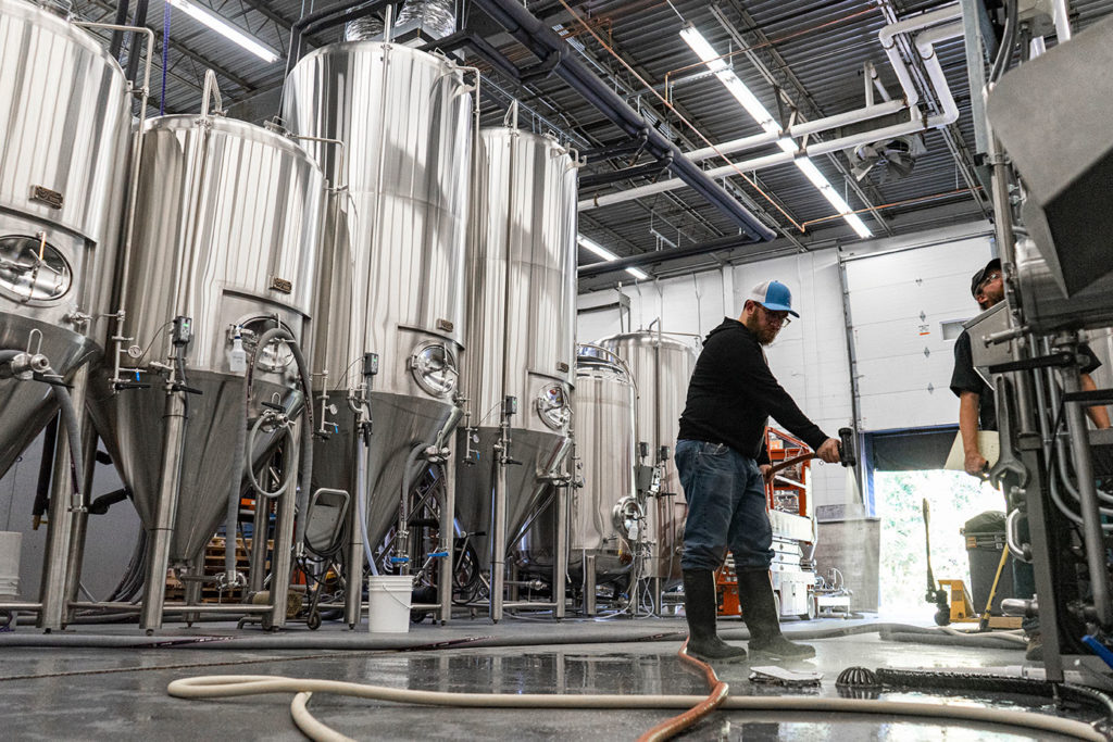 Falling Knife Brewing Co. brewer spraying floors